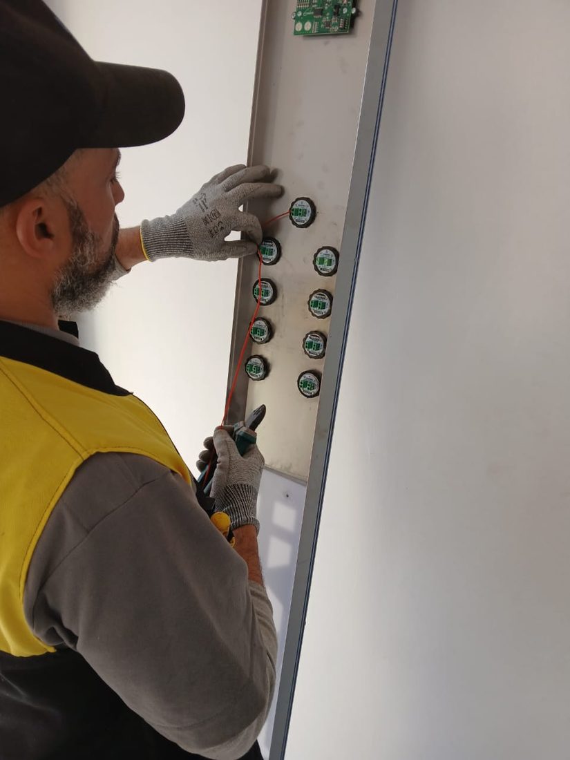 Technicien TGI vérifiant les boutons de cabine d'ascenseur