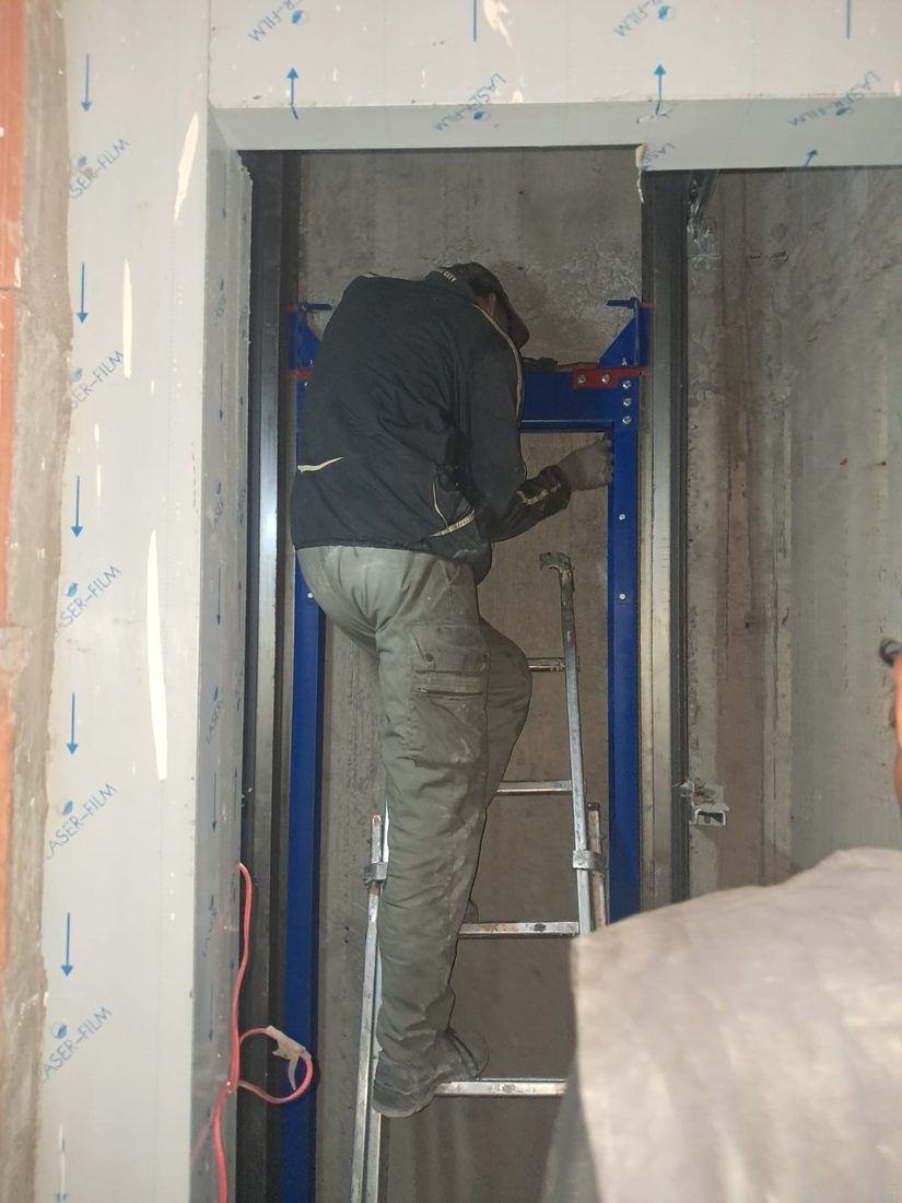 Technicien TGI câblant une porte palière d'ascenseur