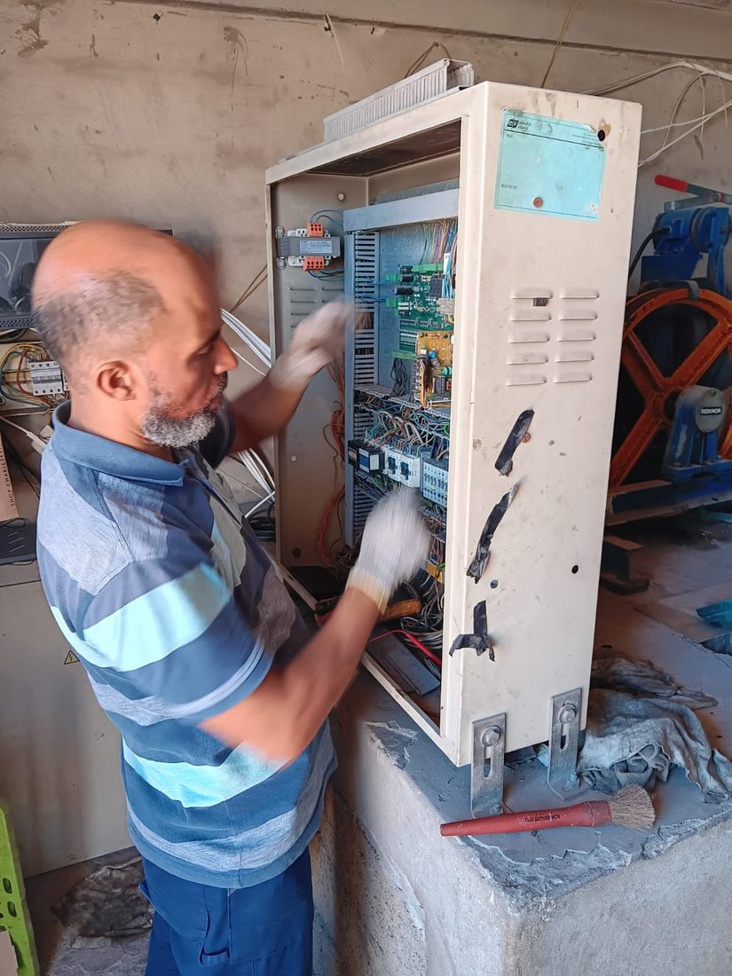 Technicien TGI réglant l'armoire de commande d'un ascenseur