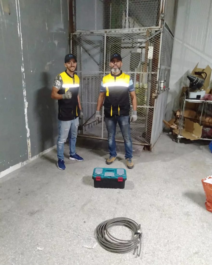 Techniciens TGI devant une cabine d'ascenseur à Casablanca