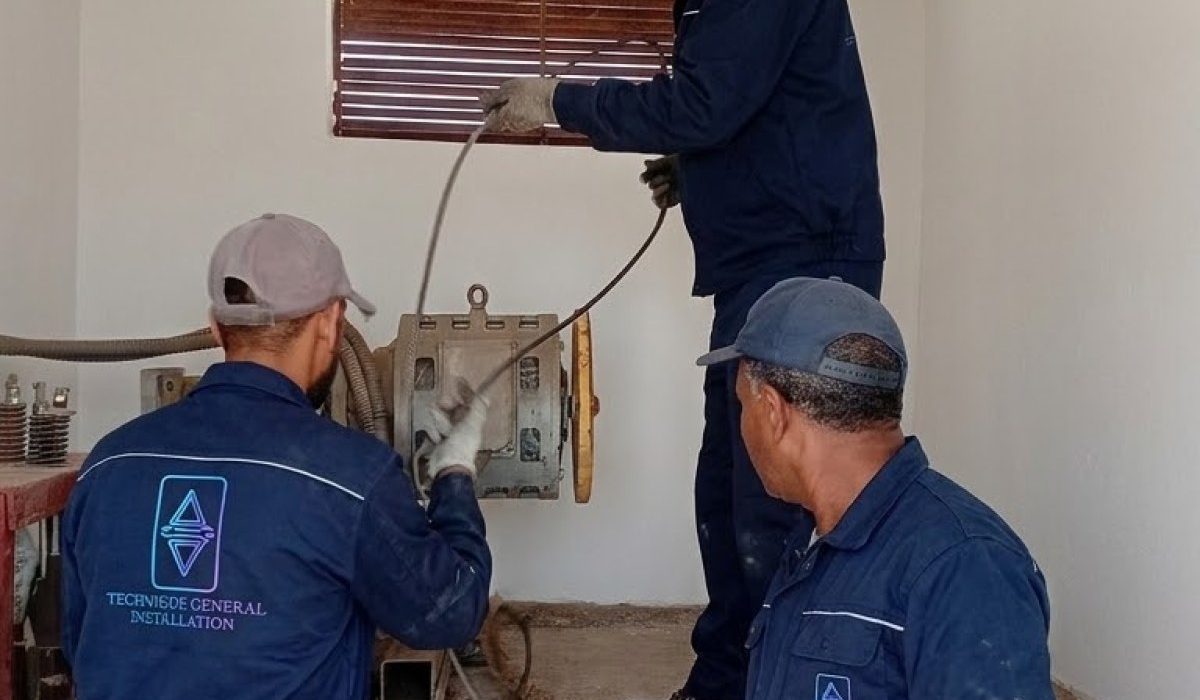 Équipe TGI installant un ascenseur dans un local technique