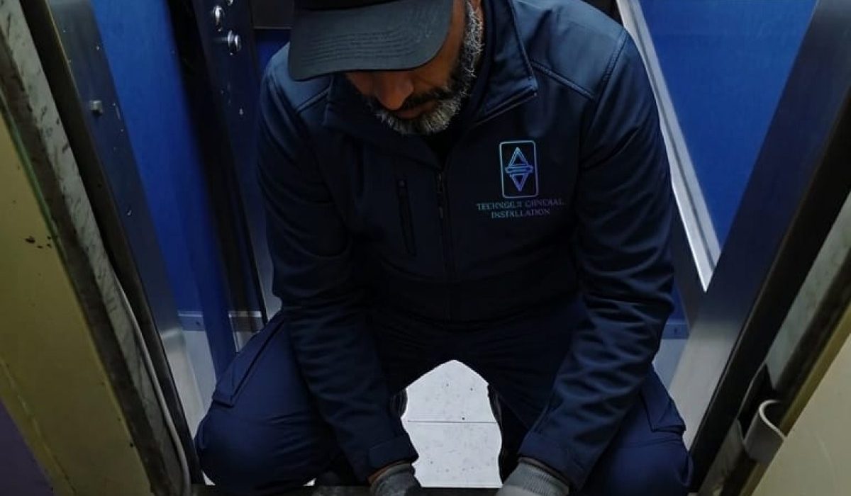 Technicien TGI en intervention dans une cabine d'ascenseur