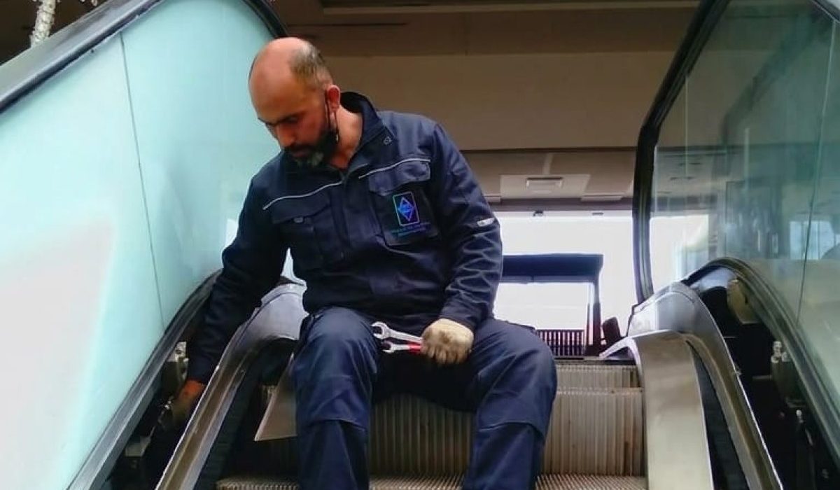 Technicien TGI en maintenance d'un escalier mécanique