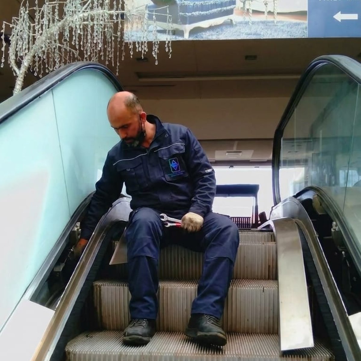 Technicien TGI en maintenance d'un escalier mécanique