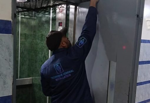 Technicien TGI installant une porte palière d'ascenseur neuve