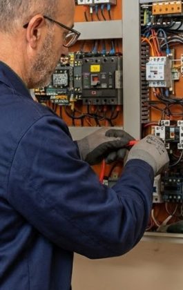 Technicien TGI intervenant sur une armoire de commande d'ascenseur