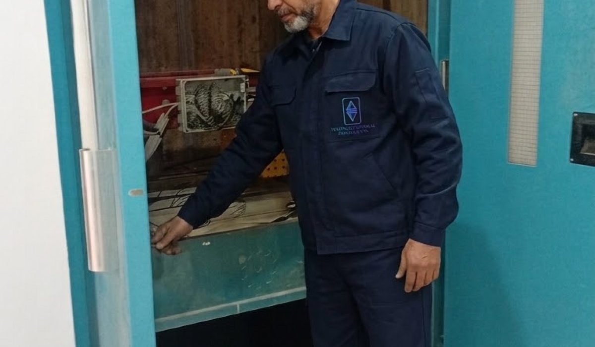 Technicien TGI posant une porte palière d'ascenseur