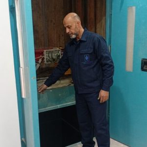 Technicien TGI posant une porte palière d'ascenseur