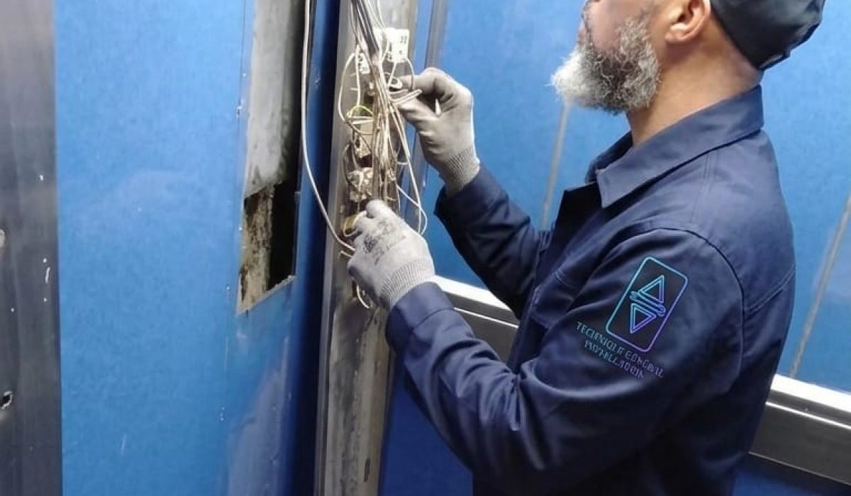 Technicien TGI réglant une porte palière d'ascenseur