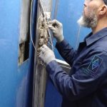 Technicien TGI réglant une porte palière d'ascenseur
