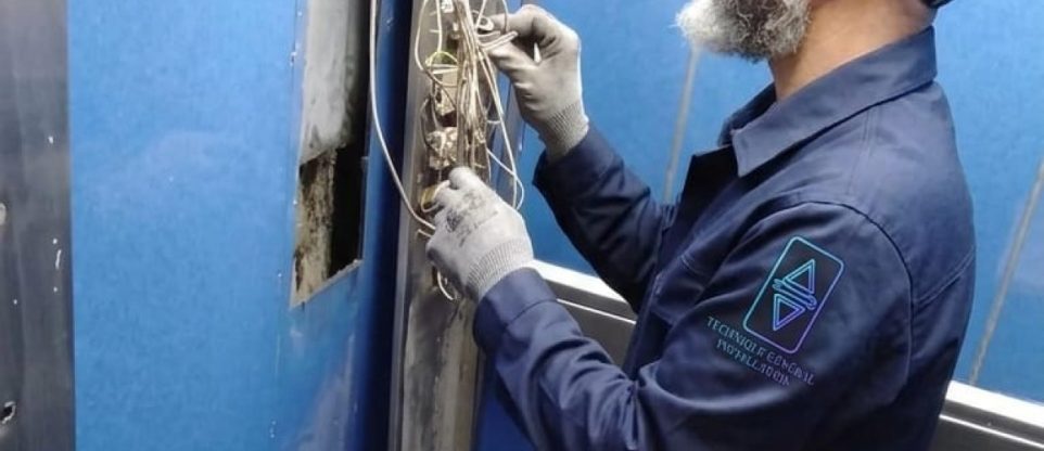 Technicien TGI réglant une porte palière d'ascenseur